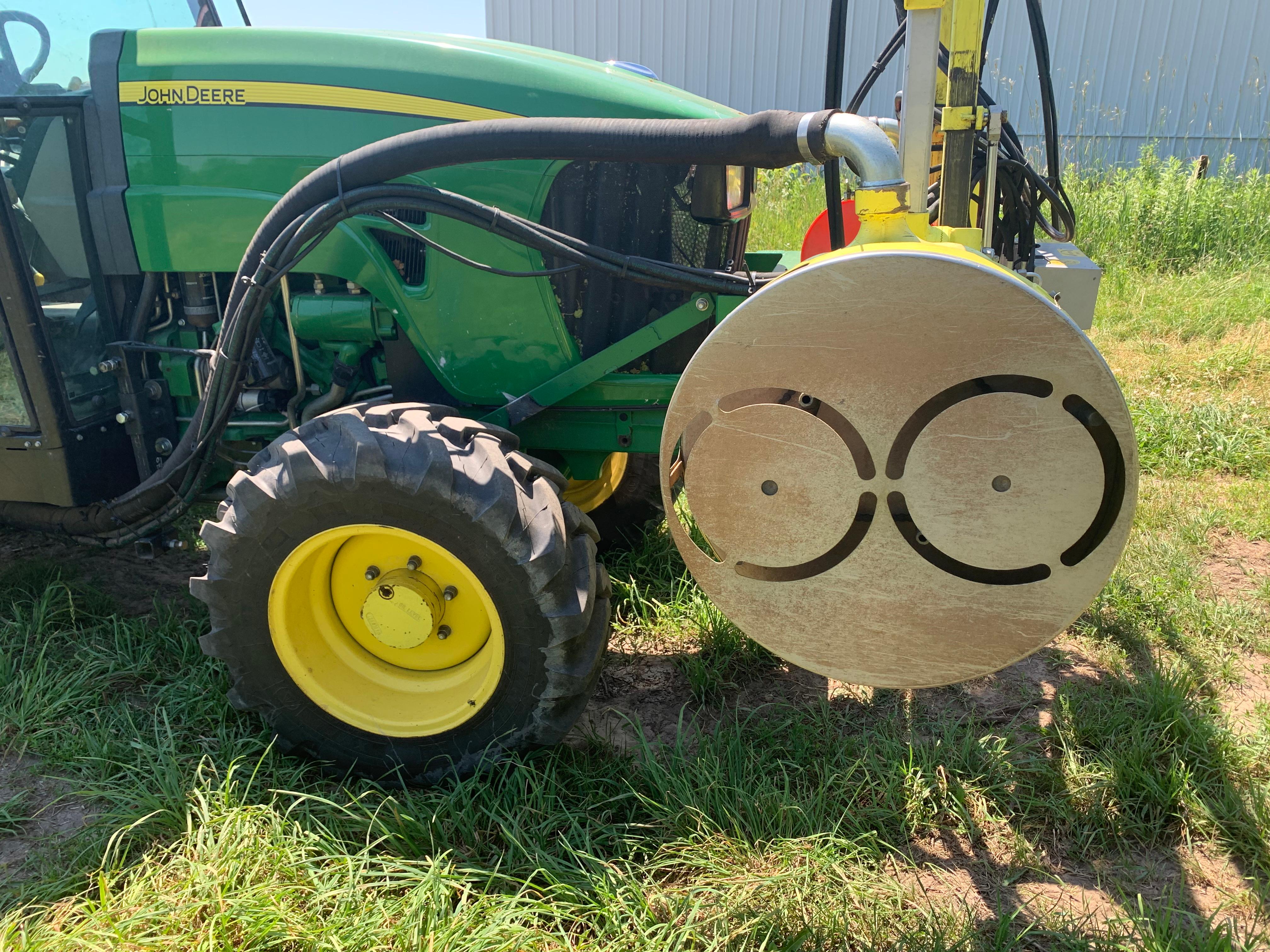 Air-pulse mechanical defoliation system mounted on a vineyard tractor, used extensively for early leaf removal in Michigan viticulture.